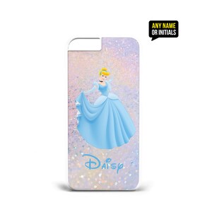 Op de afbeelding: Een witte iPhone-hoes met een glinsterende roze en paarse achtergrond. De hoes heeft een cartoonafbeelding van Assepoester in haar blauwe baljurk. De tekst "Daisy" is in blauw onderaan de hoes gedrukt.