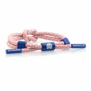 May include: A pink and white patterned rope bracelet with a blue adjustable clasp featuring a lion logo. The bracelet has the word "RASTACLAT" printed on the clasp.