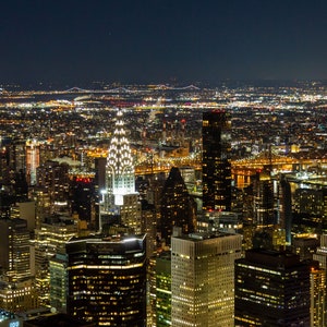 New York City night view from he Empire State Building featuring the Chrysler Building.