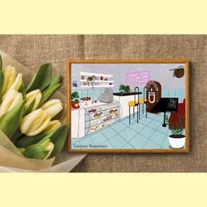 May include: A framed illustration of a retro cafe interior with a jukebox, display case of pastries, and the text "Maybell's Coffee Shop". A bouquet of yellow tulips rests on the left.