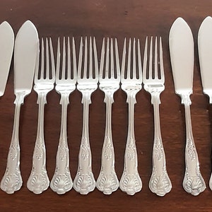 May include: A set of 12 silver-plated cutlery pieces, including 6 butter knives and 6 forks. The cutlery has an ornate design with a floral pattern.