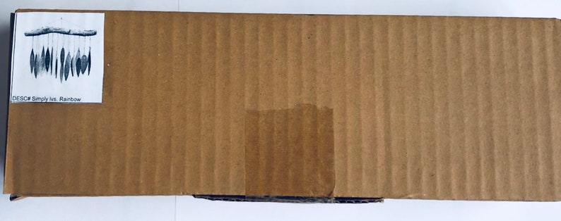 May include: A cardboard box with a label that reads "DESC: Simplylis. Rainbow". The label also shows a picture of a rainbow-colored wind chime.