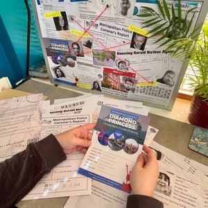 May include: A detective-themed scene with a corkboard featuring photos, notes, and red string connecting them. A brochure for the "Diamond Princess" Amsterdam cruise is held in the foreground. Documents and a plant are also visible.