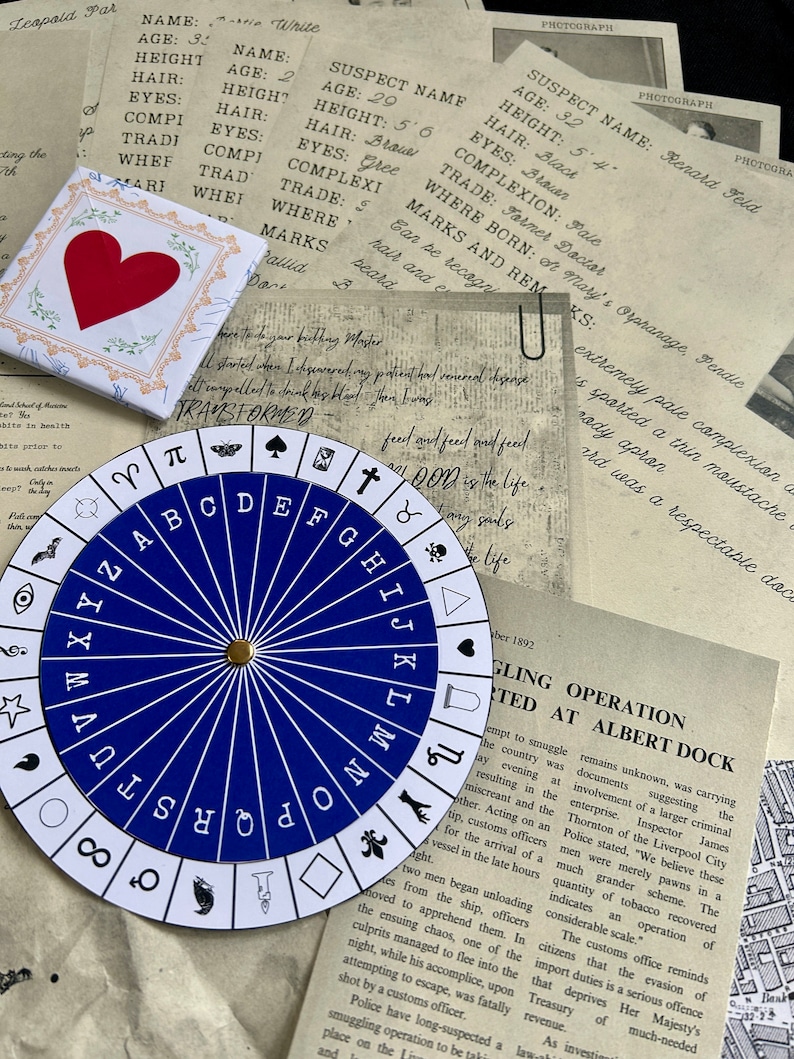 May include: A blue and white alphabet wheel with a gold pointer. The wheel is surrounded by old, faded paper documents with handwritten text.