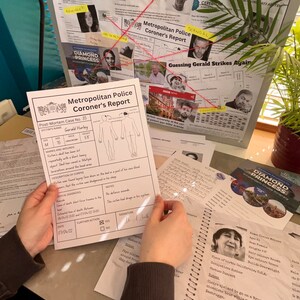 May include: A crime scene investigation board with photos, notes, and a coroner's report. The report details a post-mortem case with the victim's name, age, and cause of death. A spiral notebook and other documents are also present, suggesting a detective theme.