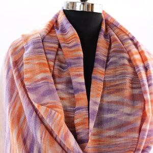 May include: A soft, lightweight scarf with a striped pattern in shades of purple, orange, and white.