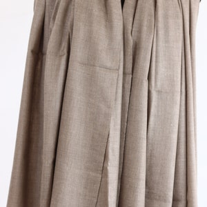 May include: A brown pashmina shawl draped over a mannequin. The shawl is made of a soft, lightweight fabric and has a subtle sheen.