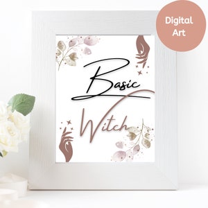 May include: A white framed print with the words "Basic Witch" in black and brown script. The print features illustrations of hands, stars, and botanical elements in muted tones. A round sticker in the upper right corner reads "Digital Art".