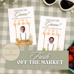 May include: Two white cards with the text "Who Has The Groom?" and "Reveal Amber's Freshly Picked Fiancé". The cards feature a market stall design with a photo cutout. The phrase "Fresh Off The Market Scratch Off Game" is also visible.