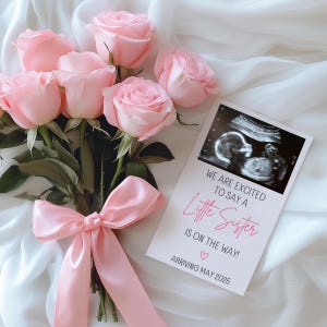 Könnte beinhalten: Ein Strauß hellrosa Rosen, gebunden mit einem passenden Satinband, neben einer Karte mit einem Ultraschallbild. Auf der Karte steht: "WE ARE EXCITED TO SAY A Little Sister IS ON THE WAY! ARRIVING MAY 2025."