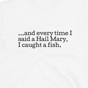 May include: White t-shirt with black text that reads "...and every time I said a Hail Mary, I caught a fish."