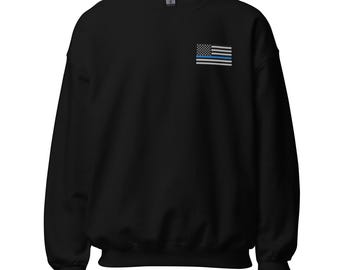 May include: Black sweatshirt with a thin blue line American flag on the left chest.