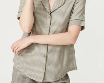 May include: A striped pajama set with a short-sleeved button-up top and matching shorts. The set is in a light green and white color.