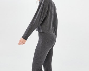 May include: A gray long-sleeved top with a cropped hem and matching gray flared pants.