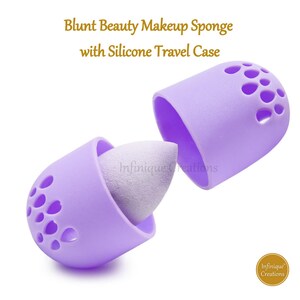 May include: Purple silicone makeup sponge holder with a white makeup sponge inside. The holder has a  pattern of small holes and is open on one side. The holder is labeled "Infinifique Creations".