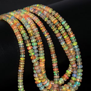 May include: A strand of multi-colored opal beads. The beads are round and have a iridescent sheen. The beads are strung on a clear thread.