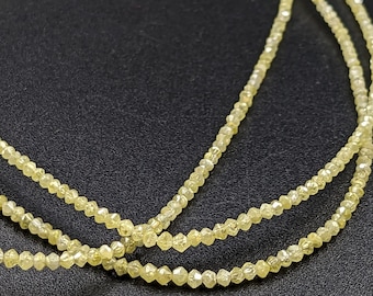 May include: A strand of yellow diamond beads, with multiple strands of beads layered on top of each other. The beads are small and have a faceted, rough cut.