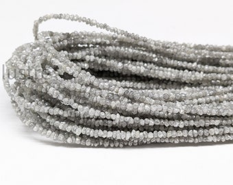 May include: A strand of gray rough diamond beads. The beads are small and irregular in shape, and they are strung together on a clear thread.