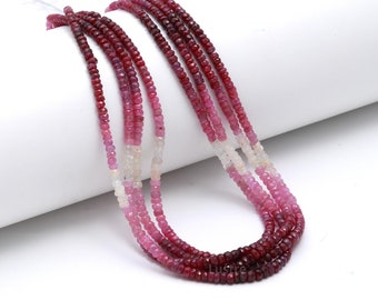 May include: A strand of pink, red, and white gemstone beads. The beads are faceted and have a graduated color effect.