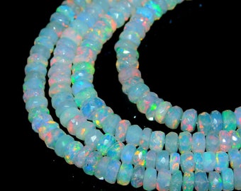 May include: A strand of white opal beads with iridescent rainbow flashes. The beads are faceted and have a slightly irregular shape. The strand is made of multiple rows of beads.
