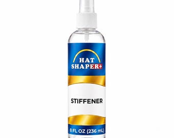 May include: A clear plastic spray bottle containing hat stiffener. The label features a blue and gold design with the text HAT SHAPER+ STIFFENER and 8 FL OZ (236 mL) printed on the front. The bottle has a white spray nozzle and cap.