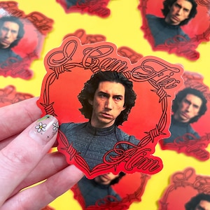 May include: Red sticker with a portrait of a man and the text "I Can Fix Him" in a heart-shaped barbed wire design. The background is yellow.