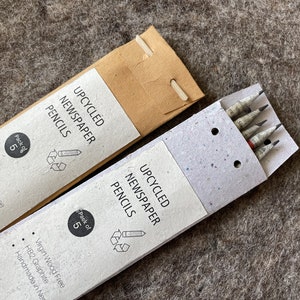 May include: Two packs of upcycled newspaper pencils. Each pack contains five pencils. The packaging is made of recycled paper. The pencils are HB2 graphite and handmade in Nepal.