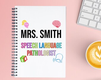 May include: A white spiral-bound notebook with the name "MRS. SMITH" in large black letters. Below, the words "SPEECH LANGUAGE PATHOLOGIST" are in colorful text. The notebook has small illustrations of a brain, speech bubbles, and a cube.