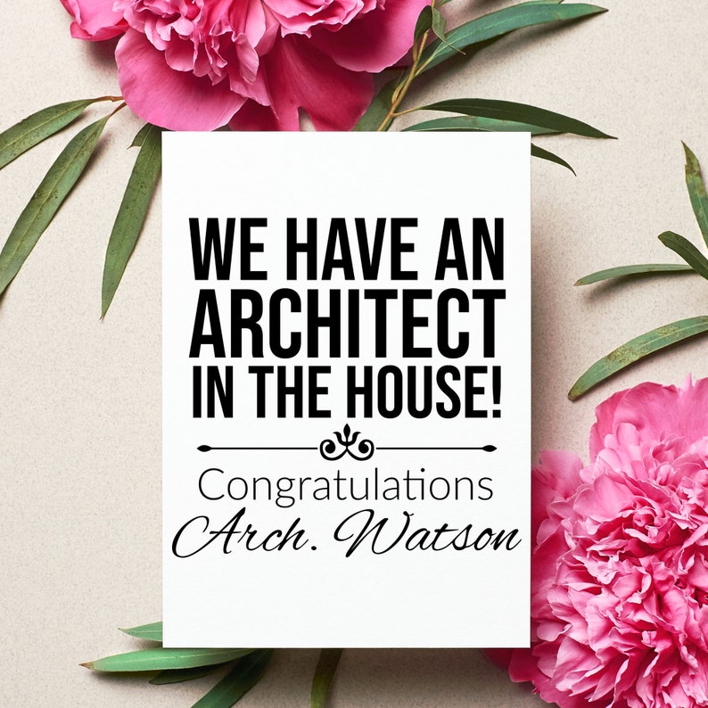 May include: A white card with black text that reads "We have an architect in the house! Congratulations Arch. Watson" surrounded by pink flowers and green leaves.