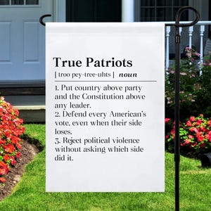 May include: A white rectangular garden flag featuring black text that defines the term True Patriots. The text includes a phonetic pronunciation, the noun classification, and three numbered points regarding country, the Constitution, and voting.