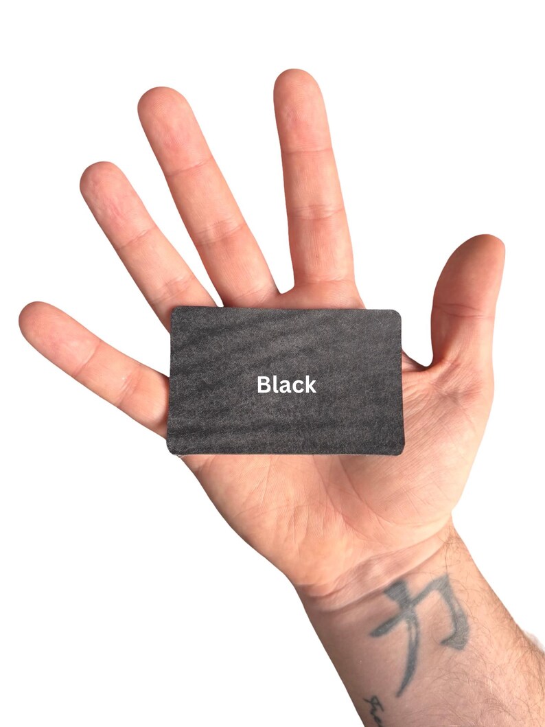 Puede incluir: Una tarjeta rectangular con una superficie texturizada de color gris oscuro que presenta la palabra Black impresa en blanco en el centro. La tarjeta tiene esquinas redondeadas y un acabado mate, ofreciendo un dise&ntilde;o simple para etiquetado.