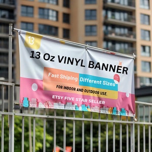 May include: A pink and blue banner with the text "13 Oz VINYL BANNER" in white. The banner also includes the text "Fast Shipping Different Sizes" and "FOR INDOOR AND OUTDOOR USE."  The banner also says "ETSY FIVE STAR SELLER".