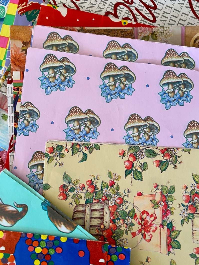 Peut inclure: Un ensemble de papiers d'emballage color&eacute;s avec diff&eacute;rents motifs. La feuille sup&eacute;rieure pr&eacute;sente un fond rose avec un motif r&eacute;p&eacute;t&eacute; de champignons bruns et de fleurs bleues. La deuxi&egrave;me feuille a un fond jaune avec un motif r&eacute;p&eacute;t&eacute; de fraises rouges et de feuilles vertes. La troisi&egrave;me feuille a un fond bleu clair avec un motif r&eacute;p&eacute;t&eacute; de points color&eacute;s.