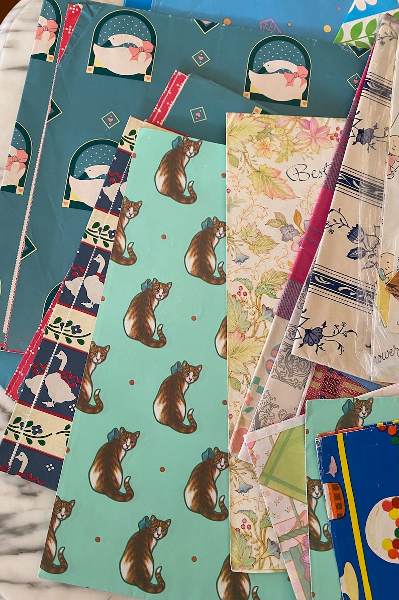 Peut inclure: Un assortiment de papiers d'emballage color&eacute;s avec diff&eacute;rents motifs, notamment des chats, des oiseaux et des fleurs. Le papier est parfait pour emballer des cadeaux et ajouter une touche festive &agrave; toute occasion.