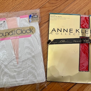 May include: Two packages of vintage pantyhose on a wooden surface. One package is labeled "Round the Clock Pantyhose" and the other is an "Anne Klein Collections" box. The Anne Klein box has red and black accents and the text "Resort 1991 Colors".