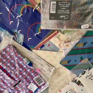 Peut inclure: Un assortiment de papiers cadeaux aux motifs color&eacute;s, dont des motifs m&eacute;talliques, arc-en-ciel, c&oelig;urs et un motif avec des canards. Le papier cadeau est emball&eacute; dans du plastique et comprend une &eacute;tiquette de prix.