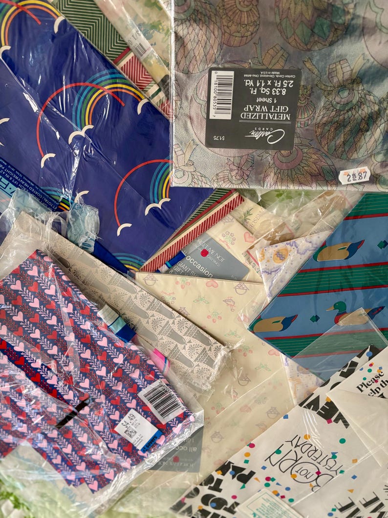 Peut inclure: Un assortiment de papiers cadeaux aux motifs color&eacute;s, dont des motifs m&eacute;talliques, arc-en-ciel, c&oelig;urs et un motif avec des canards. Le papier cadeau est emball&eacute; dans du plastique et comprend une &eacute;tiquette de prix.