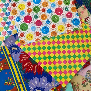 Peut inclure: Un ensemble de papiers d'emballage color&eacute;s avec diff&eacute;rents motifs, y compris des cercles, des carr&eacute;s et des fleurs. Le papier est parfait pour emballer des cadeaux ou cr&eacute;er des objets artisanaux.