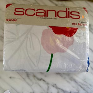 May include: A packaged full bed set featuring a floral pattern. The bedding set is white with red and pink flowers, green stems, and gray leaves. The packaging reads "scandis" and "4 piece full bed set".