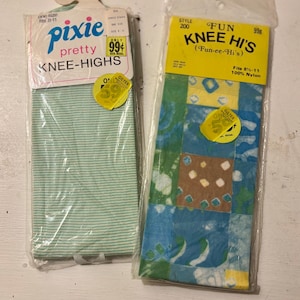 May include: Two pairs of vintage knee-high socks in plastic packaging. One pair is light green with horizontal stripes, labeled "pixie pretty KNEE-HIGHS." The other pair is patterned with blue, green, and brown squares, labeled "FUN KNEE HI'S."