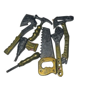 May include: A set of miniature tools in gold and silver tones, including a saw, hammer, wrench, axe, and screwdriver. The tools are made of metal and have a realistic appearance.