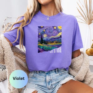 K&ouml;nnte beinhalten: Violettes T-Shirt mit einem Druck von Van Goghs Gem&auml;lde "Sternennacht". Das Kunstwerk zeigt einen wirbelnden Nachthimmel, ein Dorf und den Text "LET IT GOGH". Das Shirt wird mit Jeansshorts kombiniert.