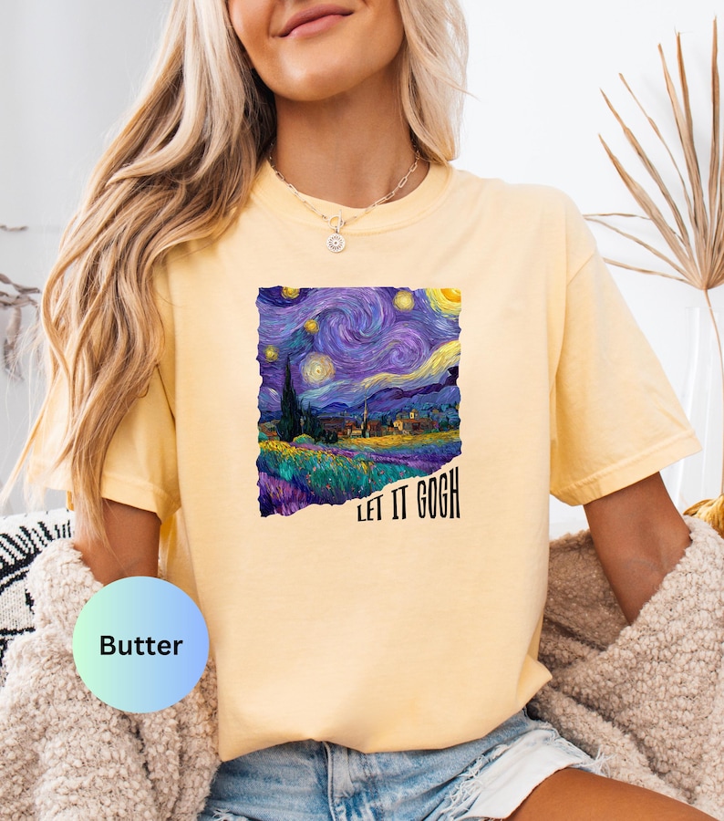 K&ouml;nnte beinhalten: Hellgelbes T-Shirt mit einem Druck von Van Goghs Gem&auml;lde "Sternennacht". Das Design zeigt wirbelnde Blau-, Lila- und Gelbt&ouml;ne mit dem Text "LET IT GOGH" in Schwarz. Das T-Shirt hat kurze &Auml;rmel und eine lockere Passform.
