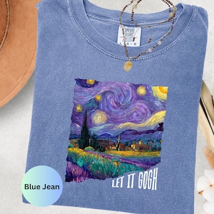 K&ouml;nnte beinhalten: Blaues Jeans-T-Shirt mit einem farbenfrohen Druck von Van Goghs Gem&auml;lde "Sternennacht". Der Schriftzug "LET IT GOGH" ist wei&szlig;. Eine Halskette mit Anh&auml;nger liegt auf dem T-Shirt.