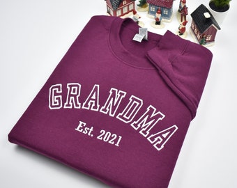 May include: Burgundy sweatshirt with white text that reads "Grandma Est. 2021".