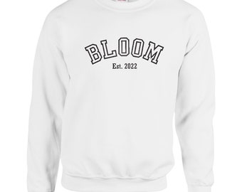 May include: White sweatshirt with black text that reads "BLOOM Est. 2022" in an arched font.