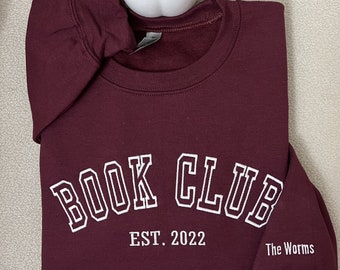 May include: Burgundy sweatshirt with white embroidered text that reads "BOOK CLUB EST. 2022 The Worms".