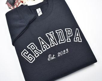May include: A black sweatshirt with white text that reads "GRANDPA Est. 2023".