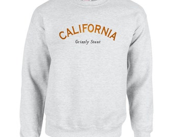 May include: A gray sweatshirt with the text "CALIFORNIA" in orange and "Grizzly Stunt" in black.