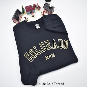Custom embroidered sweatshirt with athletic font. Colorado Mom embroidered crewnecks with custom font embroidery. Black sweatshirt with nude gold embroidery. Perfect personalized gifts for dad, mom, grandpa, grandma, couples and loved ones.